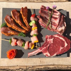 An image of the Perrys Super Deluxe BBQ pack including a British tomahawk steak, British prime pork rack of ribs, British lamb cutlets and free range chicken kebabs